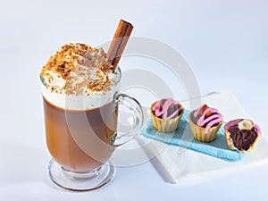 Cappuccino in a glass, Irish glass, cinnamon stick, ground nut and chocolate chips.Tartlets with chocolate paste and hazelnuts, co