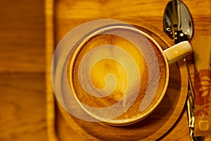 Cappuccino or latte with frothy foam is heart shape, Coffee cup top view brown tone. Cafe and bar.