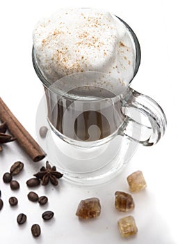 Cappuccino or latte, popular hot drink of the day. With thick milk foam and cinnamon. Decorated coffee beans, spices and