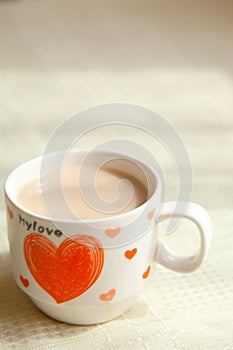 Cappuccino in a small cup. Art mug with a red heart. Romantic theme