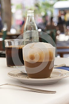 Cappuccino on table in Mediterranean cafe with blurred background