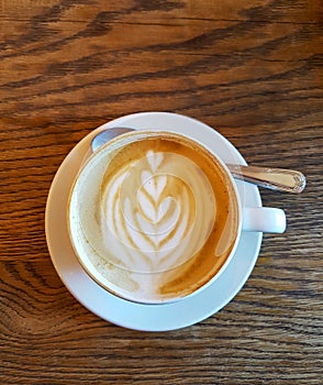 Cappuchino coffee in white porcellan cup and saucer with spoon a