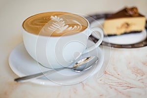 Cappuchino or latte coffe in a white cup on with a cake