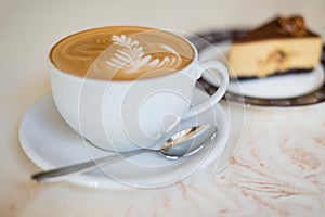 Cappuchino or latte coffe in a white cup on with a cake photo