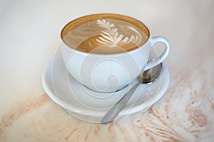 Cappuchino or latte coffe in a white cup on a light background photo