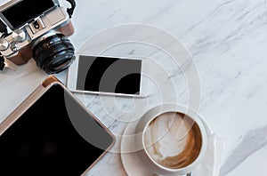 Cappucino, tablet, phone and camera on a white table