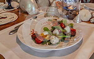 Caprese salad with cherry tomatoes, mozzarella, basil, and arugula