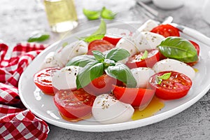 Caprese salad. Salad with mozzarella cheese fresh tomatoes, basil leaves and olive oil. Italian food