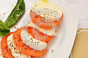 Caprese salad with ripe tomatoes and mozzarella cheese with fresh basil leaves