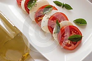 Caprese salad with ripe tomatoes and mozzarella cheese with fresh basil leaves. Italian food.