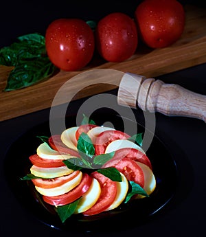 Caprese salad with tomato basil and cheese dark and wooden background photo