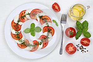 Caprese salad with tomatoes and mozzarella from above on wooden