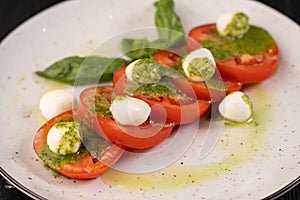 Caprese salad on white plate in italian restaurant. Italian food and healthy vegetarian food