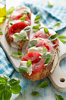 Caprese sandwich based on sourdough bread with the addition of tomatoes, mozzarella cheese, fresh basil and olive oil