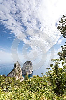 Capri Italy, island in a beautiful summer day, with faraglioni rocks and natural stone arch.