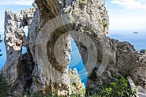 Capri Italy, island in a beautiful summer day, with faraglioni rocks and natural stone arch.