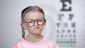 Capricious little girl afraid of eyeglasses, feeling insecure, vision correction