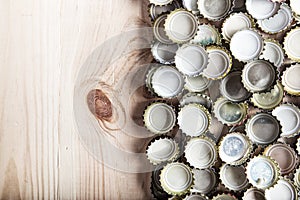 Caps of beer on a wooden board, top view