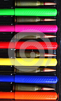 Caps Of Colored Felt Tip Pens And Rifle Bullets Laid Out Together In A Pen Case