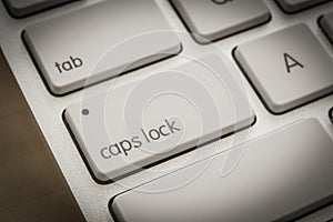 Caps lock button on white keyboard, dark filter