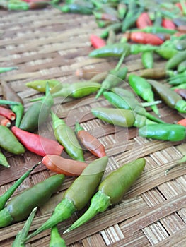 Capsicum annuum,Bird`s Eye Chilli,Thai pepper,Thai Herbals have Green chili Red chili ,Depth of Field for copyspace on brown bambo