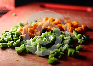 Capsicum and carrot cut into small pieces,finely chopped vegetables on a chopping board