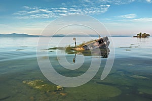 capsized boat in shallow water, sandbar visible