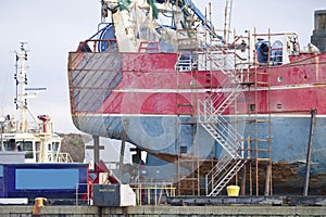 Capsized ship vessel and rescue lift crane at port dock for repair of shipwreck