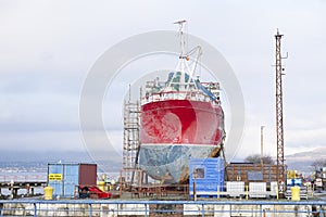 Capsized ship vessel and rescue lift crane at port dock for repair of shipwreck