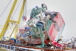 Capsized ship vessel and rescue lift crane at port dock for repair of shipwreck