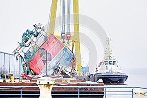 Capsized ship vessel and rescue lift crane at port dock for repair of shipwreck