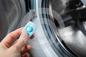 Capsule with liquid powder in the washing machine with laundry, close-up.