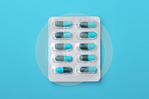 Capsule medicine in pack, antibiotic pills on blue background