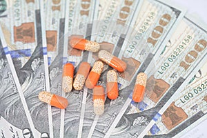 Capsule medicines on hundred-dollar bills