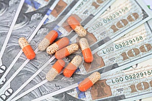 Capsule medicines on hundred-dollar bills