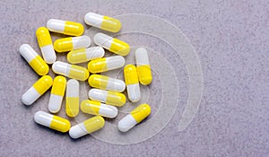 The capsule with yellow caps on grey background