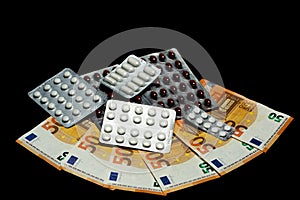 Capsules and blisters with drugs on euro bills - an expensive treatment