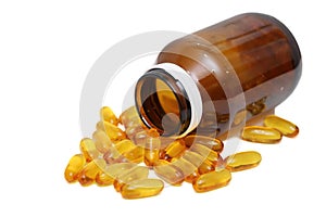 Capsules of fish oil spilled out from the bottle