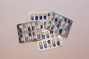 Capsules medication in white and blue packaging. 10