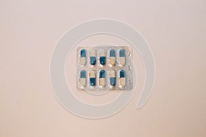 Capsules medication in white and blue packaging. 10