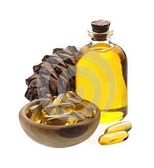 Capsules of oil turpentine with cedar cone on white backgrounds photo