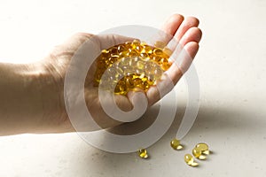 Capsules are in palm, hand food supplement oil filled capsules vitamin A, vitamin D3, fish oil, omega 3, 6, 9, evening primrose,