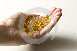 Capsules are in palm, hand food supplement oil filled capsules vitamin A, vitamin D3, fish oil, omega 3, 6, 9, evening primrose,
