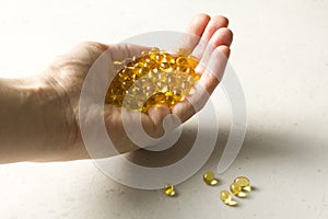 Capsules are in palm, hand food supplement oil filled capsules vitamin A, vitamin D3, fish oil, omega 3, 6, 9, evening primrose,