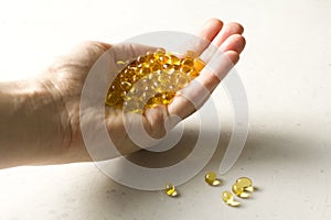 Capsules are in palm, hand food supplement oil filled capsules vitamin A, vitamin D3, fish oil, omega 3, 6, 9, evening primrose,