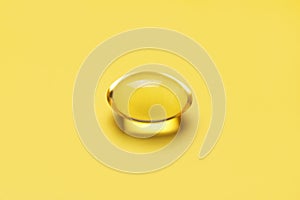 Capsules pill with vitamin D on yellow background close-up. Fish oil, Omega, Omega-3, dietary supplement, sunshine vitamin.