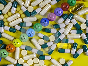 capsules pills and tablets on yellow background with funny faces