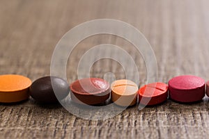 capsules on wooden table. Pills are making a line or path. Concept of way, course.