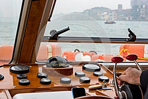 Captain driving an old wooden boat - rear view.