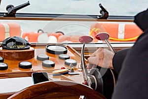 Captain driving an old wooden boat - rear view.